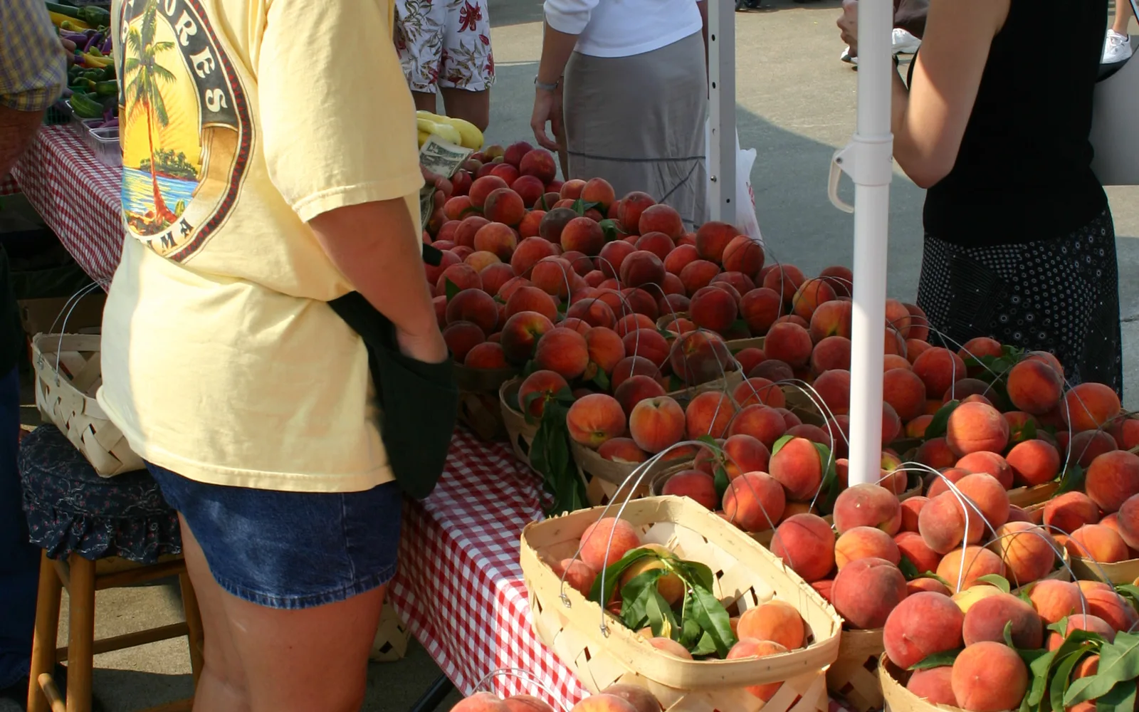 Fresh peaches displayed at a farmers market, representing local produce and farm-to-fork culture